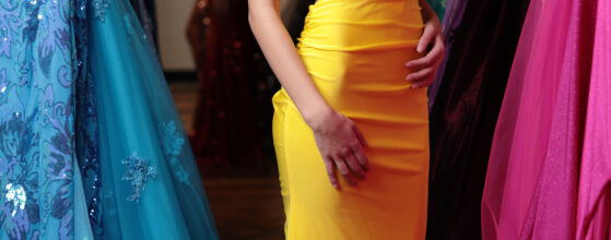 A girl smiling in a fitting room while trying on homecoming dresses near Council Bluffs IA