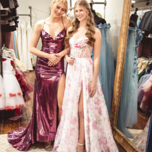 From high-shine glamour to romantic elegance—choose between a sleek pink metallic prom dress or a dreamy floral A-line with a ruched corset top. Pink metallic sleek prom dress and floral A-line gown with ruched corset top for a modern and romantic look. prom dress accessories