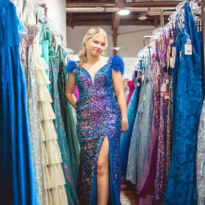Turn heads in this stunning multi-color blue prom dress, featuring elegant feather shoulder accents for a bold and refined statement. A selection of affordable homecoming dresses in bold colors at a local Iowa boutique